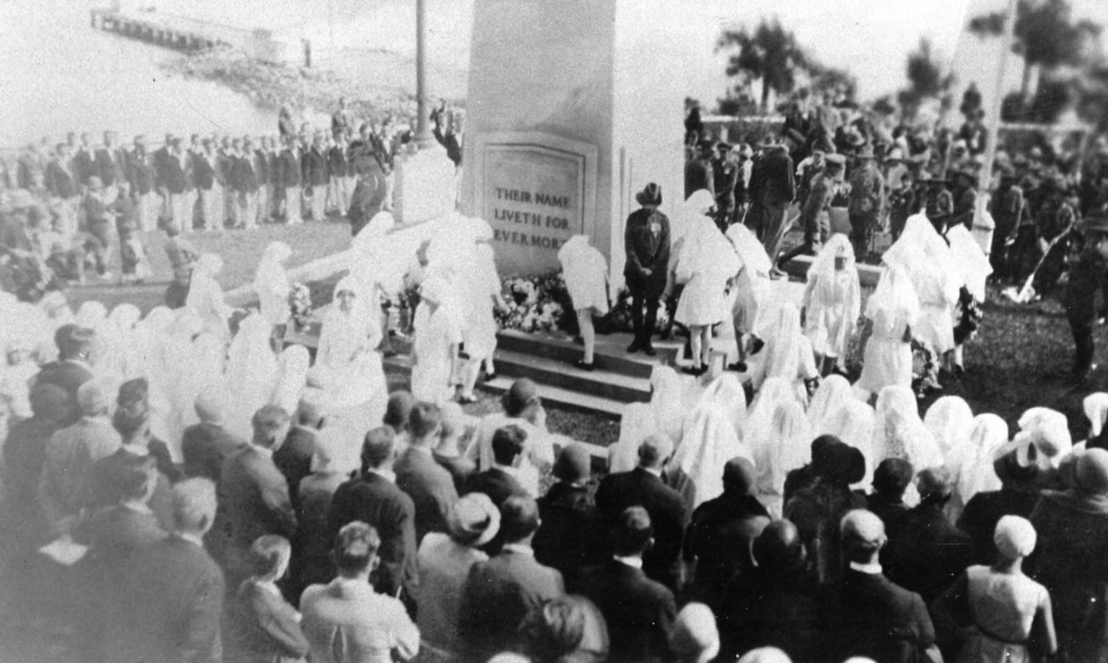 black and white image or a large crowd gathering around the memorial cenotaph 