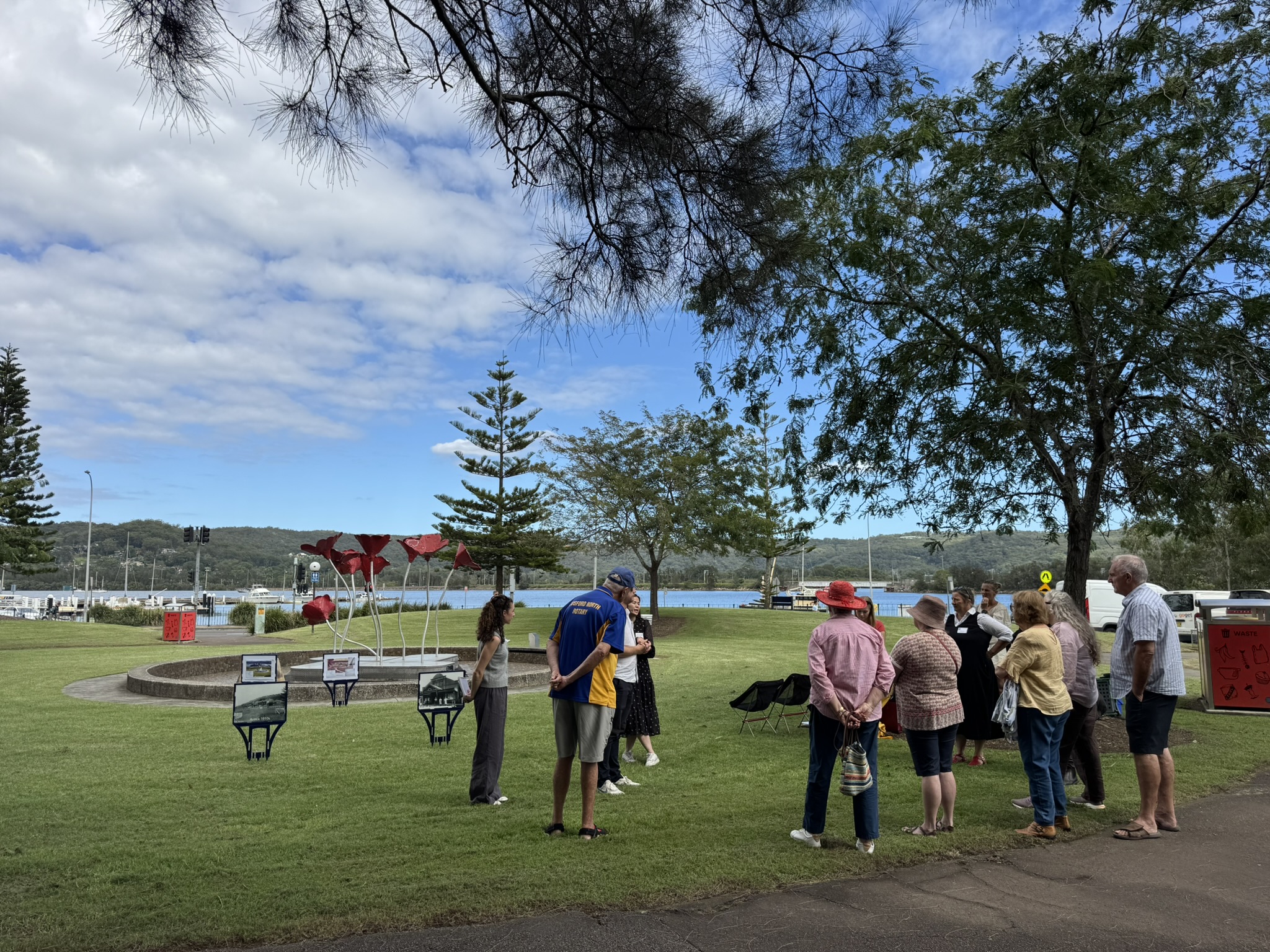 A group of people standing in a park talking to eachother