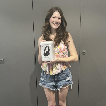 A girl standing with a new pair of headphones