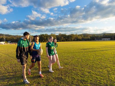 four people on a soccer field walking towards the camera 